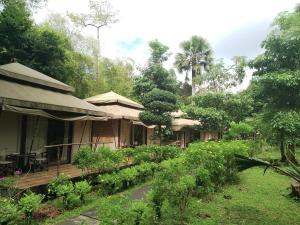 una casa con terraza de madera en un jardín en Jawa Jiwa G-Land Resort en Dadapan