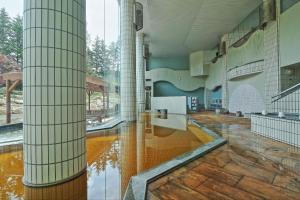 a large room with a pool of water in a building at Tokachigawa Onsen Daiichi Hotel in Otofuke