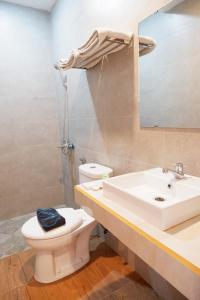 y baño con lavabo, aseo y espejo. en Hotel Netral Jombang, en Jombang