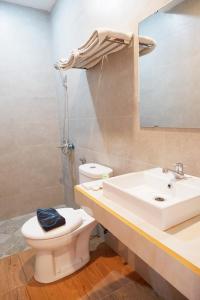 a bathroom with a sink and a toilet and a mirror at Hotel Netral Jombang in Jombang