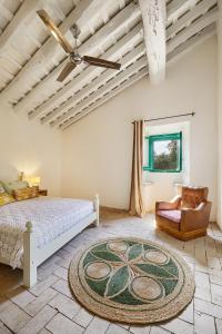 een slaapkamer met een bed, een stoel en een tapijt bij Mas Ferrer by 123ole in Sant Andreu del Terri