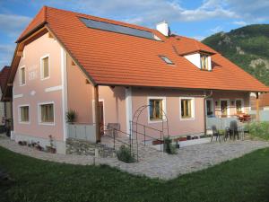 ein Haus mit einem orangenen Dach und einer Terrasse in der Unterkunft GästeHaus Rudolf u. Sandra DENK in Wösendorf