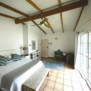 a bedroom with a large bed with a wooden ceiling at Sky Tyde's Beach House in Port Shepstone