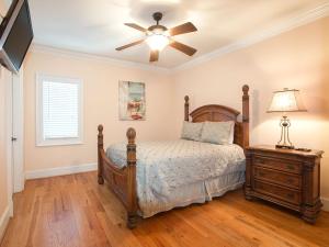 1 dormitorio con 1 cama y ventilador de techo en Villa Mariposa, en Tybee Island