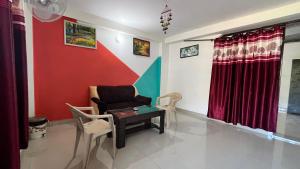 a living room with a chair and a table at Sunrise View Homestay in Kasauli