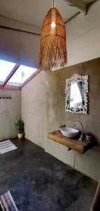 La salle de bains est pourvue d'un lavabo et d'un miroir mural. dans l'établissement Sky Tyde's Beach House, à Port Shepstone