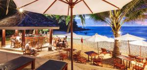 a restaurant on the beach with people sitting at tables and umbrellas at Wellness & Spa, Villa STELLA - heated pool, facilities for children, close to beaches and the sea, Medulin - Istria in Pomer