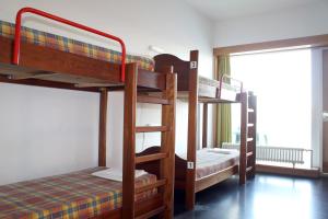 Cette chambre comprend 3 lits superposés et une fenêtre. dans l'établissement HI Viana do Castelo - Pousada de Juventude, à Viana do Castelo