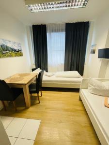 マインツにあるApartments Mainzのテーブルとベッド1台付きの部屋、ダイニングルームが備わる客室です。