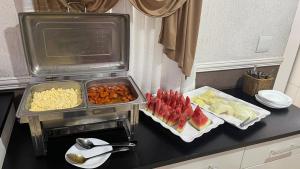 a kitchen with two trays of food on a counter at Hotel Tenda Brigadeiro SP in Sao Paulo