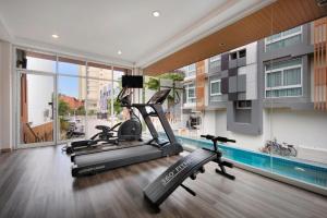 a gym with a treadmill and a swimming pool at Prime Square Hotel in Chiang Mai