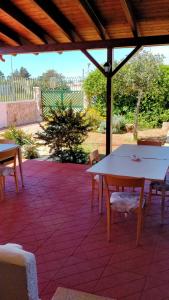 - une table et des chaises blanches sur la terrasse dans l'établissement Villa Itaca, à Sant'Isidoro