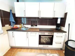 a kitchen with white cabinets and a sink at Fewo Albglück in Albstadt