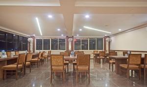 a dining room with tables and chairs and a whiteboard at Hotel Luxura, Ahmedabad in Ahmedabad