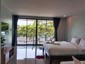 a bedroom with a bed and a view of a pool at Baan Ampai Beach Hotel in Hua Thanon Beach