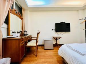 宜蘭市的住宿－慕夏精品旅館，酒店客房配有书桌和床。