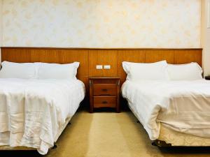 two beds sitting next to each other in a room at Mucha Boutique Hotel in Yilan City
