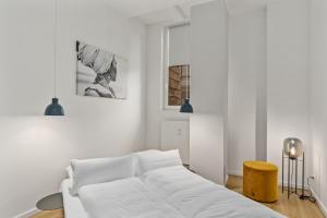 a white living room with a white couch and a stool at MEL&BENS Loft-Appartements Terrasse Weserstadion in Bremen