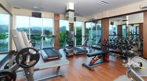 a gym with several treadmills and ellipticals at Emersia Hotel and Resort in Bandar Lampung