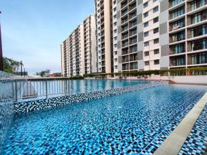 una piscina frente a algunos edificios altos en Cikgukay Desaru Homestay Apartment With Pool View WiFi & Netflix, en Bandar Penawar