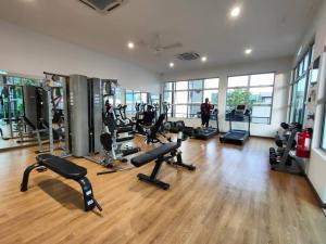 un gimnasio con varias cintas de correr y equipos de ejercicio en una habitación en Cikgukay Desaru Homestay Apartment With Pool View WiFi & Netflix, en Bandar Penawar