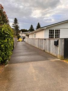 una entrada que conduce a una casa con una valla en The perfect getaway for two in a large suite en Whanganui