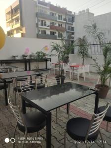 a table and chairs on a patio with a building at Hotel Shree Shyam By WB Inn in Gurgaon