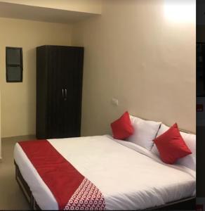 a bedroom with a bed with red and white pillows at Hotel Shree Shyam By WB Inn in Gurgaon