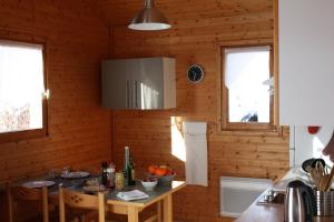a kitchen with wooden walls and a table in a room at Volcans Vacances Les Chalets Du Lac in Aydat +29 photos