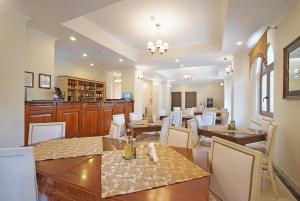 a dining room with wooden tables and white chairs at Hotel Moldavia in Slănic-Moldova