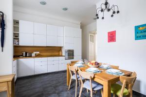 eine Küche und ein Esszimmer mit einem Holztisch und Stühlen in der Unterkunft Captain Buda Apartment in Budapest