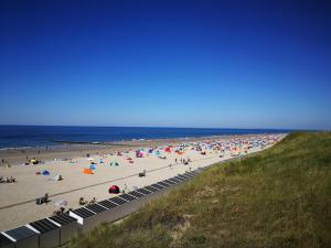 a beach with a lot of people on it at Vakantiehuis Domburg 100 meter van het strand - veel privacy - eigen parkeerplaats. in Domburg +6 photos