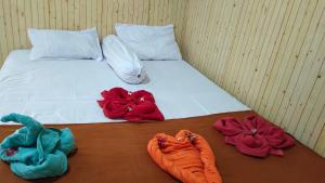 - un lit avec des serviettes rouges et bleues dans l'établissement Hotel Artha, à Tjakranegara