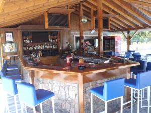 a bar in a restaurant with blue chairs at Blue Sky Hotel - Petra - Lesvos - Greece in Petra