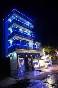 um edifício com luzes azuis à noite em ExpoMart Inn em Greater Noida