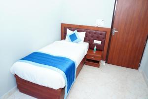 a bedroom with a large bed with a wooden headboard at ExpoMart Inn in Greater Noida