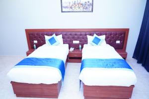 two beds in a hotel room with at ExpoMart Inn in Greater Noida