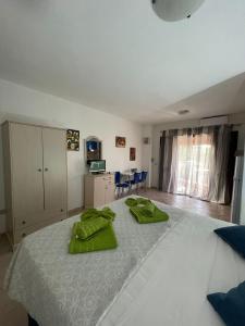 1 dormitorio con 1 cama grande y toallas verdes en CASA MONELLA mono locale vista mare en Marinella