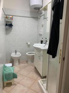 uma casa de banho branca com um WC e um lavatório em CASA MONELLA mono locale vista mare em Marinella
