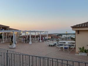 un patio con mesas y sillas y el océano en el fondo en CASA MONELLA mono locale vista mare en Marinella