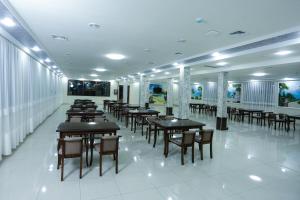 un restaurante con mesas y sillas en una habitación en Khan Palace Hotel, en Yakkasaray