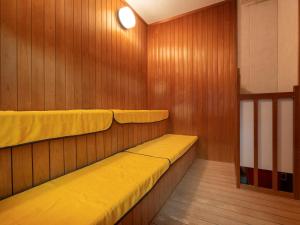 a sauna with two yellow seats in a wooden wall at Madarao Kogen Hotel in Iiyama