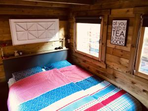 1 dormitorio con 1 cama en una cabaña de madera en Tiny House Andersom Anders, en Bad-Nieuweschans