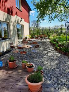 um pátio com uma mesa, cadeiras e plantas em Brauhaisla em Konradsreuth