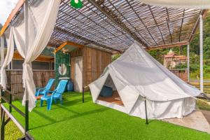 Pang Mapha的住宿－เนเจอร์วัลเล่ย์แคมป์ ปางมะผ้า，凉棚下的一个帐篷和两把椅子