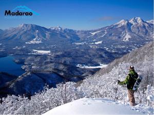 a man standing on top of a snow covered mountain at Madarao Kogen Hotel in Iiyama