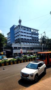 a white car parked in front of a large building at Rahul Men's AC Dormitory in Navi Mumbai