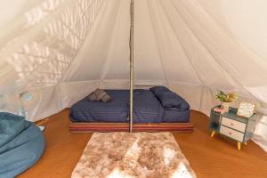 uma cama numa tenda num quarto em เนเจอร์วัลเล่ย์แคมป์ ปางมะผ้า em Pang Mapha