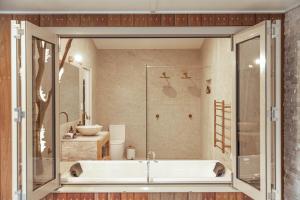 a bathroom with a tub and a shower at Bruny Island Oceanfront Luxe Cabin with Spa in Adventure Bay