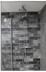 um chuveiro na casa de banho com uma parede de tijolos em BNBSpanbroek em Spanbroek